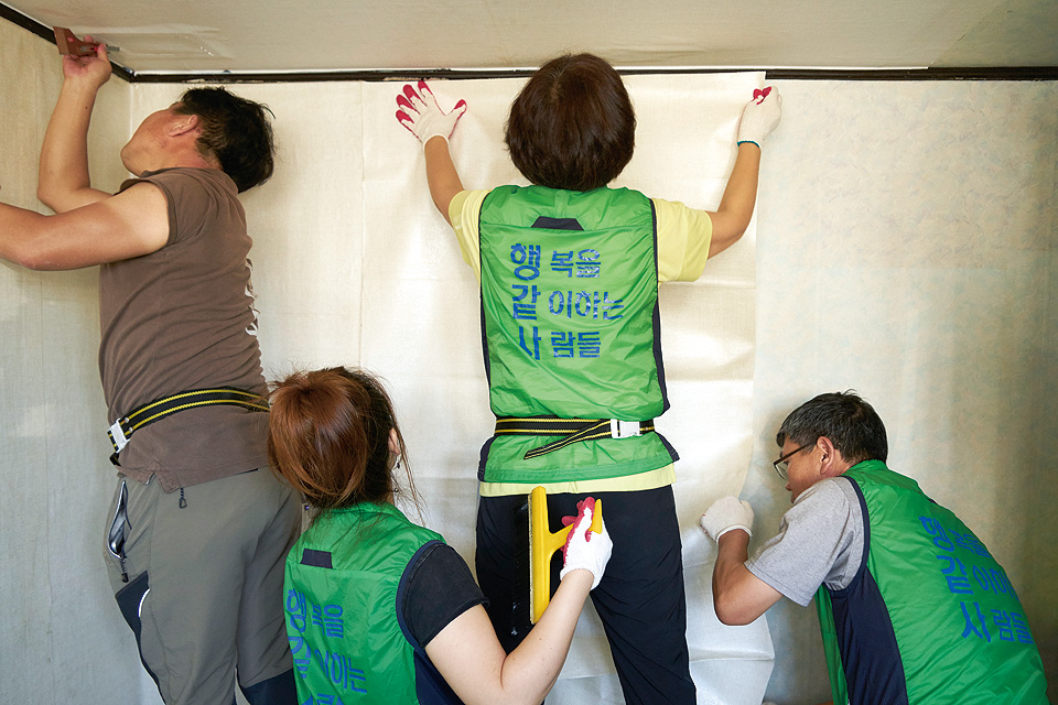 안방 도배에 열중하고 있는 안철균, 염향옥, 최순덕, 심영수 단원